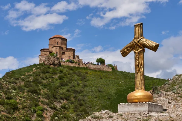 Yellow cross in the background of Jvari Monastery.Christian Cross in Mtskheta with Jvari Monastery on a hill