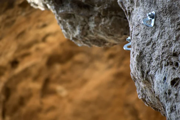 Ancre grimpant sur une paroi rocheuse. Nouveau piton de fer. Crochet d'escalade. Profondeur de champ extrême d'une vis de fixation pour grimper sur un mur de pierre . — Photo