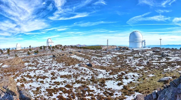 Panoramic of Calar Alto Observatory at the snowy mountain top in Almeria, Andalusia, Spain, 2019. Sky passing through against the domes. — Stock Photo, Image