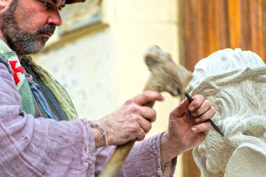 Caravaca de la Cruz, İspanya, 10 Aralık 2019: Dikenli taç ile İsa 'yı yontan heykel taşı. Profesyonel bir zanaatkar, elle çalışan bir sanatçı..