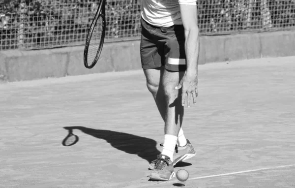 Profesyonel tenisçinin tenis raketi ve tenis topuyla çekilmiş tek renkli fotoğrafı.. — Stok fotoğraf