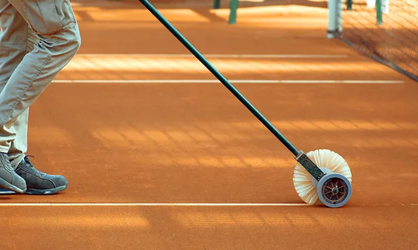 Kil tenis kortunun hatlarını temizliyorum.