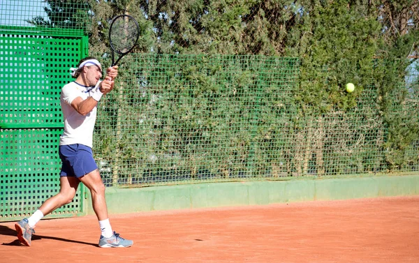 Murcia, Spanien, 26. Dezember 2019: Junger Sportler trainiert auf einem Tennis-Sandplatz in Murcia. — Stockfoto