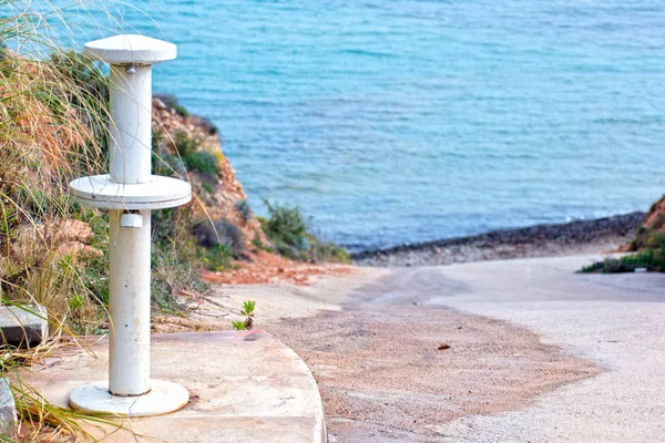 Baño de pies en la playa contra la orilla del mar durante el verano. Fuente para lavar los pies durante las vacaciones en el mar . — Foto de Stock