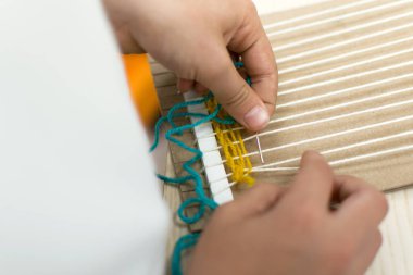 Okulda sanat terapisi dersinde el dokuması dokuma tezgahı yapan küçük çocuklar. Eğitim konsepti. Göz yaşı dokuyucu