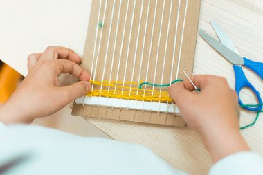 Okulda sanat terapisi dersinde el dokuması dokuma tezgahı yapan küçük çocuklar. Eğitim konsepti. Göz yaşı dokuyucu