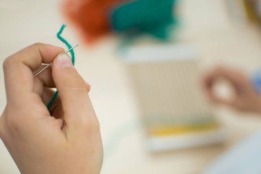 Okulda sanat terapisi dersinde el dokuması dokuma tezgahı yapan küçük çocuklar. Eğitim konsepti. Göz yaşı dokuyucu