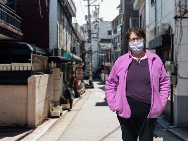 Koruyucu tıbbi maskeli yaşlı kadın boş sokaklardan izole edilmiş. Coronavirus yaşlılar tavsiyesi. Güvenilir yaşlı adamlar. Virüsün dokunarak bulaşması. Boşluğu kopyala.