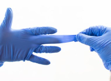 Mavi lateks eldiven takan eller grip, virüs ve koronavirüse karşı koruma sağlıyor. Sağlık ve cerrahi konsept. Cilde dokunmamak için koruyucu eldivenleri çıkarmanın doğru yolu.
