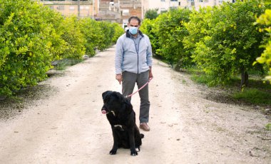 İspanya 19 Nisan 2020 'de İspanya, Murcia' da koronavirüs hastalığının yayılmasını yavaşlatmak için köpeği ile birlikte dışarı çıkan bir adam..