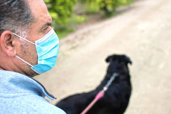 Egy ember sétáltatja a kutyáját a szabadban, miután Spanyolország lezárta a koronavírus terjedésének lelassítását Murciában, Spanyolországban, 2020. április 19.. — Stock Fotó