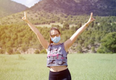 Coronavirus azalması, COVID 19 'dan normale döndü. Koruyucu tıbbi maskeli genç kadın karantina bittikten sonra özgürlüğün tadını çıkarıyor. Covid bittikten sonra rahatla.