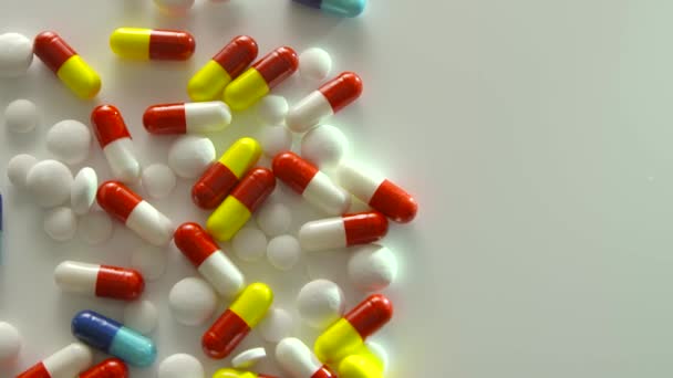 Vista superior de medicamentos recetados girando sobre una superficie blanca — Vídeos de Stock