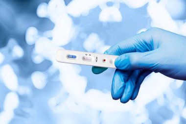 Eldivenli bir tıp çalışanı elinde Coronavirus 'un hızlı testiyle virüsün arka planına karşı çıkıyor.