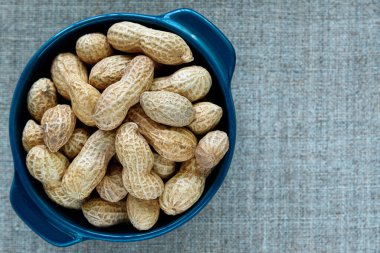 Mavi bardakta, gri yatay tuvalde kavrulmuş fıstık..