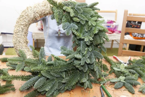 Çiçekçi bir Noel çelenk yapar