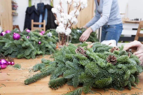 Çiçekçi bir Noel çelenk yapar