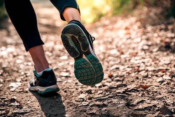 Legs of a runner in motion on a dusty trail — Stock Photo, Image