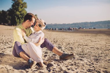 Mutlu genç çift güneşli kumsalda eğleniyor.