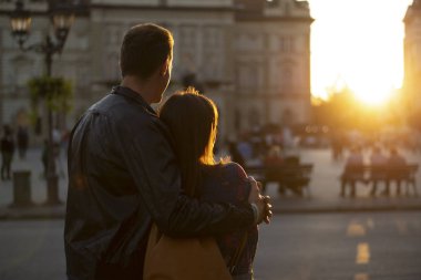 Silhouette of a young man embracing woman while watching sunset