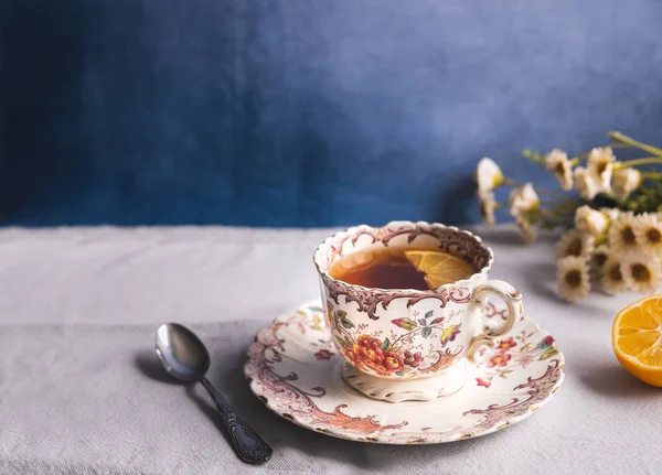 Çay ve limon dilimli zarif çiçekli bir çay fincanı.