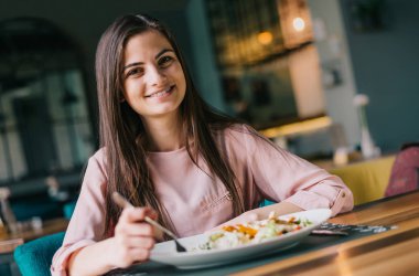 Portrait of a cute young girl at the restaurant having lunch
