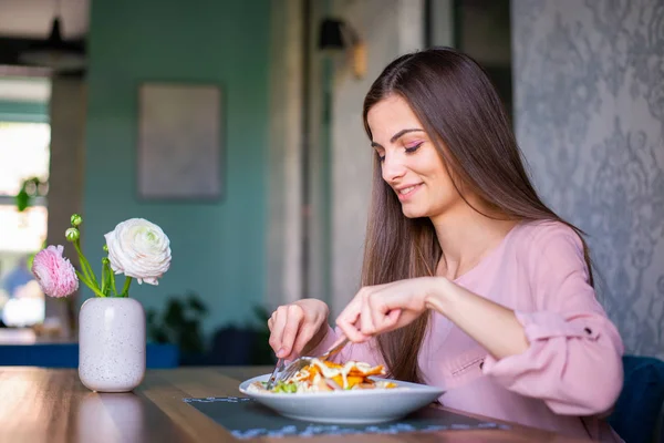 Pretty young woman eating a salad at the nice restaurant. — ストック写真