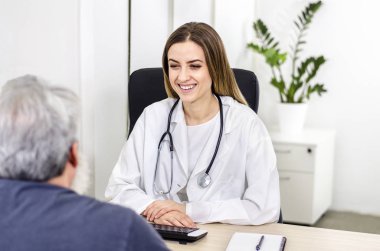 Etkili doktor-hasta iletişimi. Yaşlı hastasıyla iletişim kuran pozitif kadın doktor. 