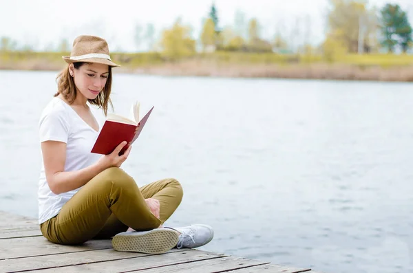 Νεαρό Κορίτσι Διαβάζει Ένα Βιβλίο Δίπλα Στη Λίμνη Κάθεται Μια — Φωτογραφία Αρχείου