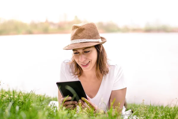 Νεαρή Όμορφη Γυναίκα Καπέλο Διαβάζει Βιβλίο Από Συσκευή Kindle Ενώ — Φωτογραφία Αρχείου