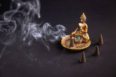 Zen meditasyonu ilham verici aromatik koni yanan ve duman yaratan. Koyu arkaplan. 