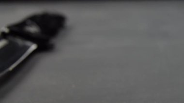 Siyah bir masa yüzeyinde siyah bir katlama bıçağı. Keskin kenar bıçağı.