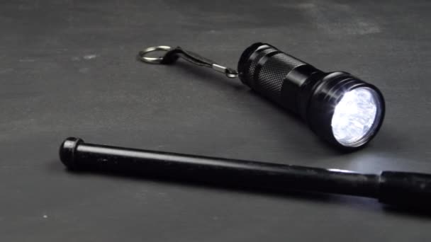 Taschenlampe Und Teleskopschlagstock Auf Einem Holztisch Bereit Für Einen Kampf — Stockvideo
