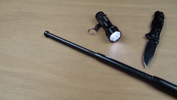 Taschenlampe Und Teleskopschlagstock Auf Einem Holztisch Bereit Für Einen Kampf — Stockvideo