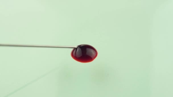 Goccia di sangue da ago ipodermico sterile versato sulla superficie di vetro. Lentamente diffusione — Video Stock