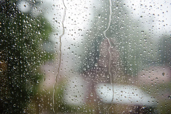 Gotas de chuva em vidro com um fundo — Fotografia de Stock