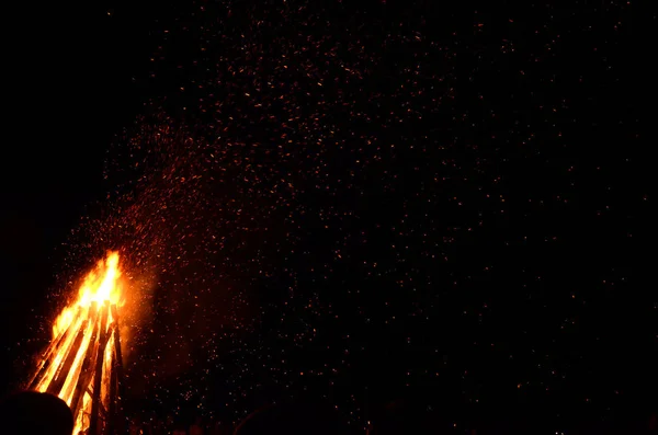 夜の空の背景に対してたき火から火花します。 — ストック写真