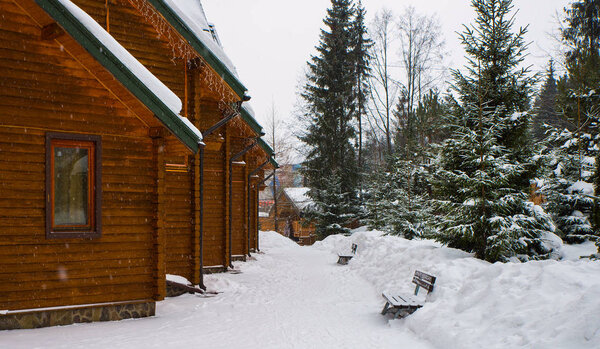  wooden houses surrounded by snow-capped trees