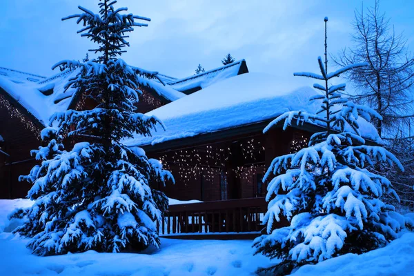 A fairy-tale house in the woods amid the snow-covered fir trees