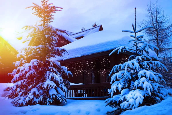 Una casa de cuento de hadas en el bosque entre los abetos cubiertos de nieve — Foto de Stock