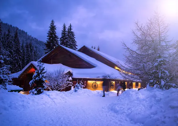 Karla kaplı çam ağaçları arasında ormanda bir masal ev — Stok fotoğraf