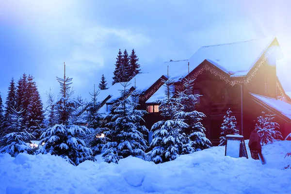 Una casa de cuento de hadas en el bosque entre los abetos cubiertos de nieve — Foto de Stock