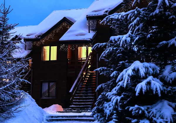 Una casa de cuento de hadas en el bosque entre los abetos cubiertos de nieve — Foto de Stock