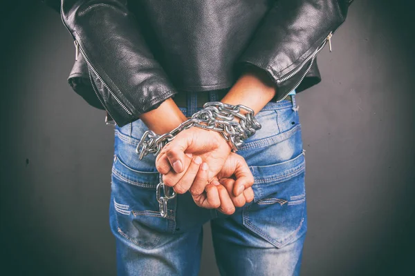 Hands of young man in chains — Stock Photo, Image