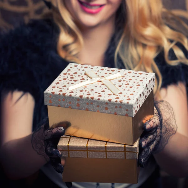 Vrouw met een gouden geschenkdozen — Stockfoto