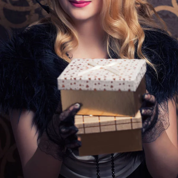 Vrouw met een gouden geschenkdozen — Stockfoto