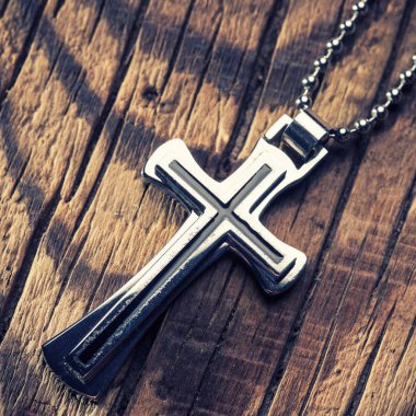 Ahşap arka plan üzerinde gümüş haç 