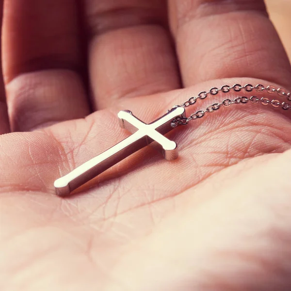 Silver cross in a hand — Stock Photo, Image