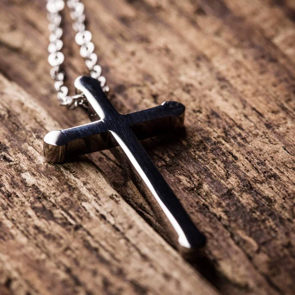 Silver cross on a wood background — Stock Photo, Image