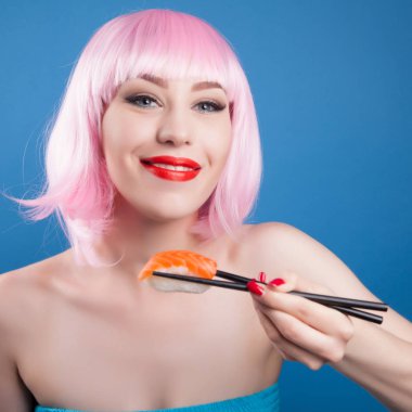 Kırmızı dudaklar ve suşi yakın çekim yemek pembe saçlı güzel kız